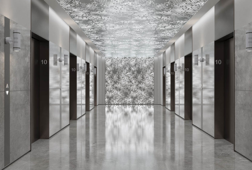 Arktura Vapor® Cumula with backlight installed on the ceiling and wall in an elevator lobby.