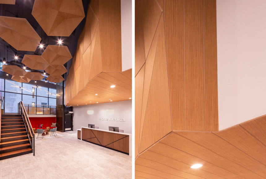A lobby with eye-catching acoustic ceiling clouds and stairs that bridge the lobby to a hallway leading to another part of the building.