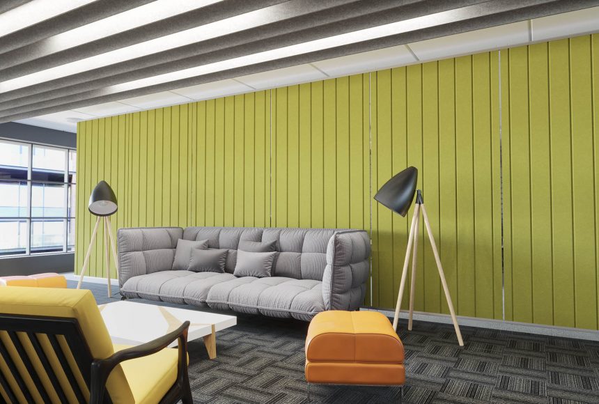 This room has a green wall with a plush, grey sofa. There’s an orange ottoman, a coffee table, a yellow chair and two lamps also in the space. 